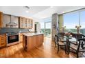 Bright kitchen with hardwood floors, stainless steel appliances, island, and dining table with glass doors to the terrace at 601 W Rosemary St # 905, Chapel Hill, NC 27516