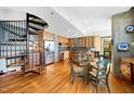 Open concept kitchen and dining area with hardwood floors, stainless steel appliances, and a spiral staircase at 601 W Rosemary St # 905, Chapel Hill, NC 27516