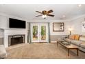 Cozy living room with a fireplace, french doors to backyard, and comfortable furnishings at 7015 Staghorn Ln, Raleigh, NC 27615