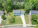 Two story home with a two car garage and large front yard landscaped with mature trees and asphalt driveway at 7209 Halstead Ln, Raleigh, NC 27613