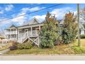 Inviting two-story home with a charming front porch, surrounded by lush greenery, offering great curb appeal at 725 S State St, Raleigh, NC 27601