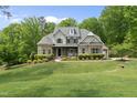 Charming two-story home with lush lawn, mature trees, and a circular driveway leading to a garage at 7517 Summer Pines Way, Wake Forest, NC 27587
