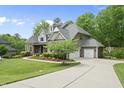 Two-story home with a well-manicured lawn, a long driveway, and a detached garage at 7517 Summer Pines Way, Wake Forest, NC 27587