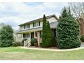 Well-manicured lawn highlights this two-story home, adorned with lush green trees and a welcoming front porch at 775 Sid Eaves Rd, Youngsville, NC 27596