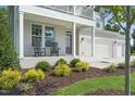 Charming two-story home featuring a covered front porch with rocking chairs and landscaped garden at 8704 Maxine St # 1, Willow Springs, NC 27592