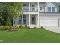 Charming two-story home featuring a covered front porch with rocking chairs and a well-manicured lawn at 8704 Maxine St # 1, Willow Springs, NC 27592