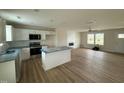 Open-concept kitchen and living room with white cabinets and stainless steel appliances at 10 Silver Ct, Smithfield, NC 27577