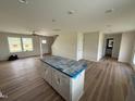 Living room features wood flooring, an island, and stairs leading to the second floor at 10 Silver Ct, Smithfield, NC 27577