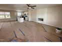 Open-concept living space with fireplace, ceiling fan, and adjacent kitchen area at 10 Silver Ct, Smithfield, NC 27577
