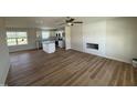 Spacious living room featuring wood-look flooring, a ceiling fan, and a cozy fireplace with modern white shiplap at 10 Silver Ct, Smithfield, NC 27577