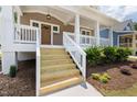 Inviting front porch with detailed white railings and wood stairs leading to the front door at 1005 Forrestal Pl, Durham, NC 27707