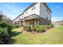 Back exterior view of townhomes with second story patios and small manicured lawns at 103 Ballyliffen Ln, Cary, NC 27519