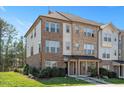 Beautiful townhome showing brick and neutral siding, manicured lawn and covered entryway at 103 Ballyliffen Ln, Cary, NC 27519