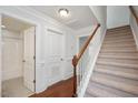 Hallway with carpeted stairs, hardwood floors, white trim, and access to bathroom at 103 Ballyliffen Ln, Cary, NC 27519