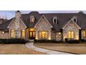 A beautifully crafted stone home featuring a front entrance with an elegant, oversized wooden door at 103 Patriot Way, Apex, NC 27523