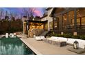 An outdoor living area featuring a luxury pool, covered patio, fire pit, and lounge furniture at 103 Patriot Way, Apex, NC 27523