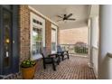 Cozy front porch with brick flooring, ceiling fan, and comfortable seating area at 107 Oxford Creek Rd, Cary, NC 27519
