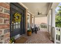 Inviting front porch features brick flooring, ceiling fan, and comfortable seating at 107 Oxford Creek Rd, Cary, NC 27519