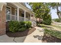 Charming home featuring a covered front porch with white columns and landscaped garden at 107 Oxford Creek Rd, Cary, NC 27519