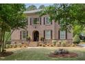 Two-story brick home with well-maintained landscaping, framed by lush green trees at 112 Aspenridge Dr, Holly Springs, NC 27540