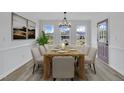 Elegant dining room with ample natural light, wood table, seating for eight, and decorative chandelier at 112 Edmondson Dr, Willow Springs, NC 27592