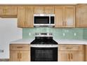 Modern kitchen featuring stainless steel appliances, light wood cabinets, and light countertops at 112 Edmondson Dr, Willow Springs, NC 27592