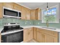 Bright kitchen features stainless steel appliances, sleek countertops, light wood cabinetry and a window overlooking the yard at 112 Edmondson Dr, Willow Springs, NC 27592