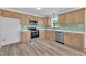 Well-lit kitchen features stainless steel appliances, light wood cabinets and modern backsplash at 112 Edmondson Dr, Willow Springs, NC 27592