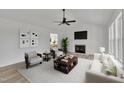 Staged living room with neutral tones, fireplace, ceiling fan, and comfortable seating arrangement at 112 Edmondson Dr, Willow Springs, NC 27592