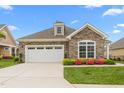 Charming single-story home with stone accents, attached garage, and colorful landscaping at 122 Tall Timber Dr, Gibsonville, NC 27249