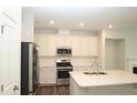 Bright kitchen featuring stainless steel appliances, white cabinets, and center island at 123 Hunston Dr, Holly Springs, NC 27540