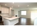 Stylish kitchen with white cabinets, stainless appliances, island, open to living area at 123 Hunston Dr, Holly Springs, NC 27540