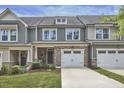Charming townhome showcasing a stone facade, attached garage, and inviting curb appeal with manicured lawn at 1238 Exchange Pl, Durham, NC 27713