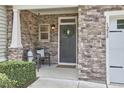Inviting front porch with stone accents, features seating, and a decorative wreath on the entry door at 1238 Exchange Pl, Durham, NC 27713