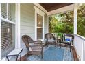 Comfortable covered porch with wicker chairs, patterned rug, and serene outdoor ambiance at 1241 Dalgarven Dr, Apex, NC 27502