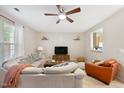 Cozy living room featuring a ceiling fan, plush sofa, and modern entertainment center at 126 Star Thistle Ln, Cary, NC 27513