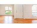 Bright entryway featuring gleaming hardwood floors, a white front door, and natural light streaming through large windows at 131 Longbridge Dr, Cary, NC 27518