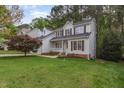 Charming two-story home with a well-manicured lawn and a cozy front porch surrounded by lush greenery at 131 Longbridge Dr, Cary, NC 27518