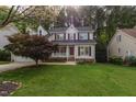 Charming two-story home with a well-manicured lawn and a cozy front porch surrounded by lush greenery at 131 Longbridge Dr, Cary, NC 27518