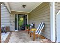 Inviting front porch with striped chairs, decorative string lights, and a view of the home's entrance at 1321 Bloomingdale Dr, Cary, NC 27511