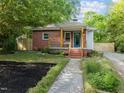 Quaint home with well-maintained lawn and stone pathway leading to the front door at 1402 W Lakewood Ave, Durham, NC 27707