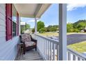 Cozy front porch seating area with a comfortable wicker chair and side table at 141 Montesino Dr, Raleigh, NC 27603