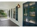 Inviting covered porch with views, featuring a blue door and a lantern-style light fixture at 1429 Raybon Dr, Wendell, NC 27591