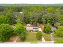 An aerial view of a residential home with solar panels and a backyard pool surrounded by lush greenery at 149 Baldwin Dr, Durham, NC 27712
