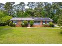 Beautiful single-story brick home with well-manicured front lawn and mature landscaping at 149 Baldwin Dr, Durham, NC 27712