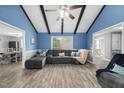 Bright living room with beamed ceilings, hardwood floors, and a comfortable gray sofa at 2005 Chalybeate Springs Rd, Fuquay Varina, NC 27526