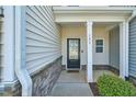 Close-up of front door featuring a window and covered entryway with stone accents at 225 Gulley Glen Dr, Garner, NC 27529