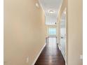 Hallway with hardwood flooring and neutral paint leading to a naturally lit living area at 225 Gulley Glen Dr, Garner, NC 27529
