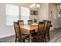 Well-lit dining room featuring a wooden table, six chairs, and modern gray flooring, perfect for Gathering meals at 253 Sweet Olive St, Clayton, NC 27527