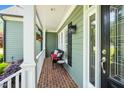 Cozy front porch with brick floor, white columns, and comfortable seating at 2633 Penfold Ln, Wake Forest, NC 27587